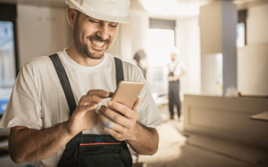 artisan du bâtiment qui regarde tolteck sur son téléphone depuis un chantier