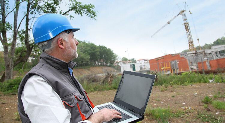 Artisans travaillant sur un chantier avec son ordinateur